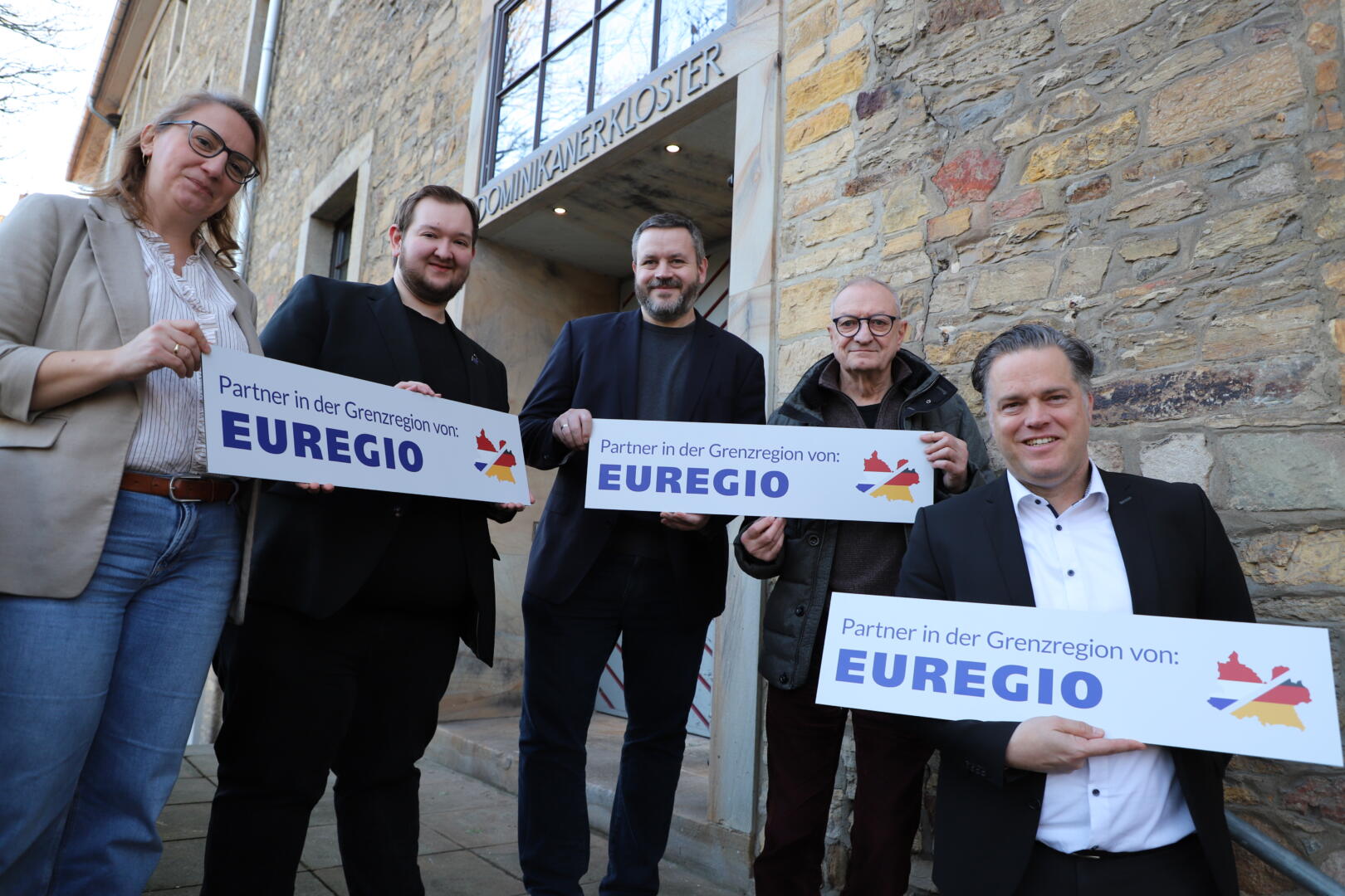 Sie präsentieren das neue EUREGIO-Schild (von links): Magdalena Knappik (Leitung Sachgebiet Stadt- und Regionalentwicklung), Lukas Ölmann (EUREGIO-Gremiumsmitglied), Hendrik Kettler (Koordinierungsstelle Regionale Kooperationen), Heiko Schlatermund (EUREGIO-Gremiumsmitglied) und Stadtbaurat Thimo Weitemeier. Es fehlt EUREGIO-Gremiumsmitglied Volker Witte. 